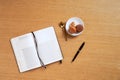 Brown and white french macarons or macaroons in a plate with a golden tea spoon by a blank recipe book and a pen, oak background Royalty Free Stock Photo