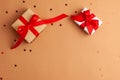 Brown and white gift boxes with tied red satin ribbon bows on brown background with red stars shapes.Christmas Holidays and Royalty Free Stock Photo