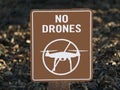 A brown and white no drones sign