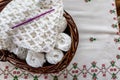 Brown wicker basket with balls of cotton, blanket with an original raised crochet stitch pattern, purple crochet hook Royalty Free Stock Photo