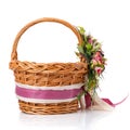 Brown wicker basket. Decor with pink flowers, greenery and ribbons. Made for Easter. Side view