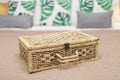 Brown Wicker storage basket on bed with many pillow