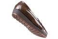 Brown women`s patent leather low-soled shoes with a tread, as if walking, on a white background Royalty Free Stock Photo