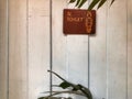 Brown women Toilet sign on the vintage white wooden wall with Natural light. Royalty Free Stock Photo