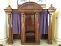 Brown wood confession booth with purple curtain