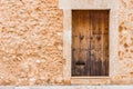Brown wood entrance door and rustic stone wall of mediterranean house Royalty Free Stock Photo