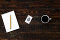 Brown wood table with coffee cup, notebook, pencil and ace card. Top view Royalty Free Stock Photo