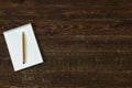 Brown wood table with notebook and pencil. Top view Royalty Free Stock Photo