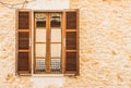 Brown wood window with open shutters and rustic stone wall background Royalty Free Stock Photo