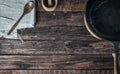 Brown wooden background with black frying pan and wooden spoon Royalty Free Stock Photo