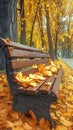 A brown wooden bench covered in yellow autumn leaves in park