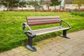 Brown wooden bench with a green meadow in the background. Lonely chairs on the lawn in the park. Royalty Free Stock Photo