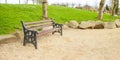 Brown wooden bench with a green meadow in the background. Lonely chairs on the lawn in the park. Royalty Free Stock Photo