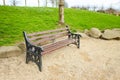 Brown wooden bench with a green meadow in the background. Lonely chairs on the lawn in the park. Royalty Free Stock Photo