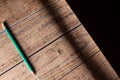Brown wooden and black background and green pencil. Background for screensavers and inscriptions