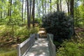 A brown wooden bridge over a creek in the garden surrounded by lush green trees and plants at Callaway Gardens Royalty Free Stock Photo