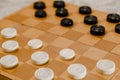 Brown wooden chessboard with classic checkers. Table game. Checkers on the playing field for the game Royalty Free Stock Photo