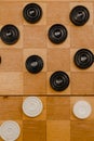 Brown wooden chessboard with classic checkers. Table game. Checkers on the playing field for the game Royalty Free Stock Photo