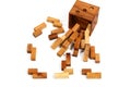 Brown wooden cube (puzzle) with wooden pieces scattered around on white Royalty Free Stock Photo