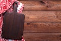 Brown wooden cutting board and red table cloth Royalty Free Stock Photo