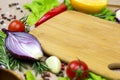 Brown wooden cutting board with summer vegetables and champignon mushroom on table background. Royalty Free Stock Photo