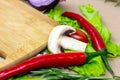 Brown wooden cutting board with summer vegetables and champignon mushroom on table background. Royalty Free Stock Photo