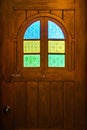 Brown wooden door with colorful stained glass Royalty Free Stock Photo