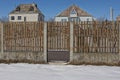 Brown wooden door on a fence wall with a gray concrete foundation Royalty Free Stock Photo