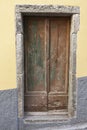 Brown wooden door in a stone wall close-up of village house. Italy . Royalty Free Stock Photo