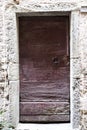 Brown wooden door in a stone wall close-up of village house. Italy . Royalty Free Stock Photo