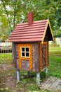 A brown wooden fairy-tale house with a chimney and carved windows on a clear sunny day. Playgrounds, sports, health
