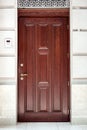 Brown wooden front door stone facade building exterior.