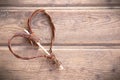 Brown wooden heart on the right side on the brown vintage wooden background.