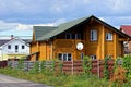 Brown wooden house behind a planted fence Royalty Free Stock Photo