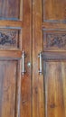 Brown wooden house door with two metal handles as backgroundÃ¢â¬âwood texture. Royalty Free Stock Photo