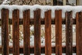 Brown wooden rural fence covered by snow.Garden fence in countryside. Cold winter scenery. Old wood plank texture Royalty Free Stock Photo