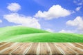 Brown wooden table board empty on Beautiful green field and blue sky with light clouds Royalty Free Stock Photo