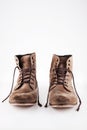 Brown worn vintage boots with untied laces in studio