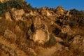 Brown yellow sandy stones, cliffs of Fiolent with dry grass and green bushes on Black Sea coast in light of sun.  South Crimea Royalty Free Stock Photo