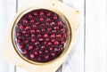 Brownie cake with chocolate icing, decorated with cranberries, on a light wooden table. Gluten-free Royalty Free Stock Photo