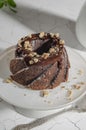 Brownie cake poured with chocolate and nuts on a white stand Royalty Free Stock Photo