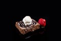 Brownie with ice cream and strawberries on a black background Royalty Free Stock Photo