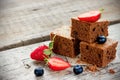 Brownie pieces with fresh berries on the old wooden background i Royalty Free Stock Photo