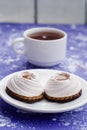 Brownie, white-pink marshmallows, jam, cookies, chocolate on a blackboard, purple background. Close-up. Top view. Place for text