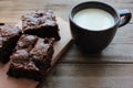 Brownies With Cherries On A Cut Board. Close-up Of Handmade Chocolate Cake And A Cup Of Milk On Wooden Table Background.