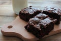 Brownies With Cherries On A Cut Board. Close-up Of Handmade Chocolate Cake And A Glass Of Milk On Wooden Table Background.