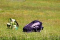 Brownsea, Dorset, England - June 02 2018: Two rucksacks, one large black and grey, one small green and patterned, in a grass mead