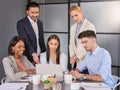 Browsing while figuring the best plan. Shot of a group of businesspeople working together on a laptop in an office. Royalty Free Stock Photo