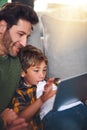 Browsing with my boy. a handsome young father and his adorable little son using a tablet together on the sofa at home. Royalty Free Stock Photo