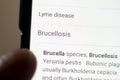 Brucellosis News on the phone.Mobile phone in hands. selective focus and chromatic aberration effects